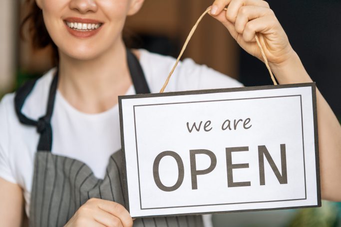 business-owner-holding-the-sign-for-the-reopening