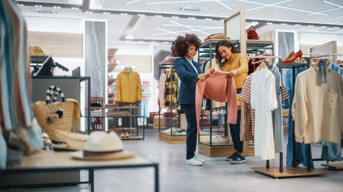 Customers,Shopping,In,Modern,Clothing,Store,,Retail,Sales,Associate,Assists